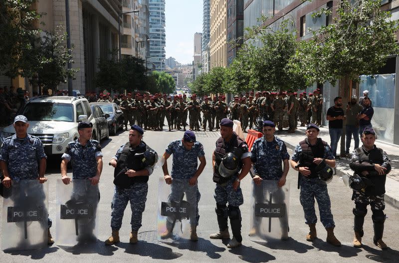 Lebanese police members and army soldiers stand guard outside a building hosting the embassy of Sweden in Beirut