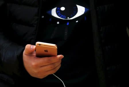 A customer holds an iPhone 6s during the official launch at the Apple store in central Sydney, Australia, September 25, 2015. REUTERS/David Gray