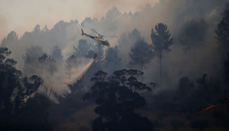 A firefighting helicopter drops water to extinguish a forest fire in Vila Velha de Rodao, near Castelo Branco, Portugal, July 27, 2017. REUTERS/Rafael Marchante