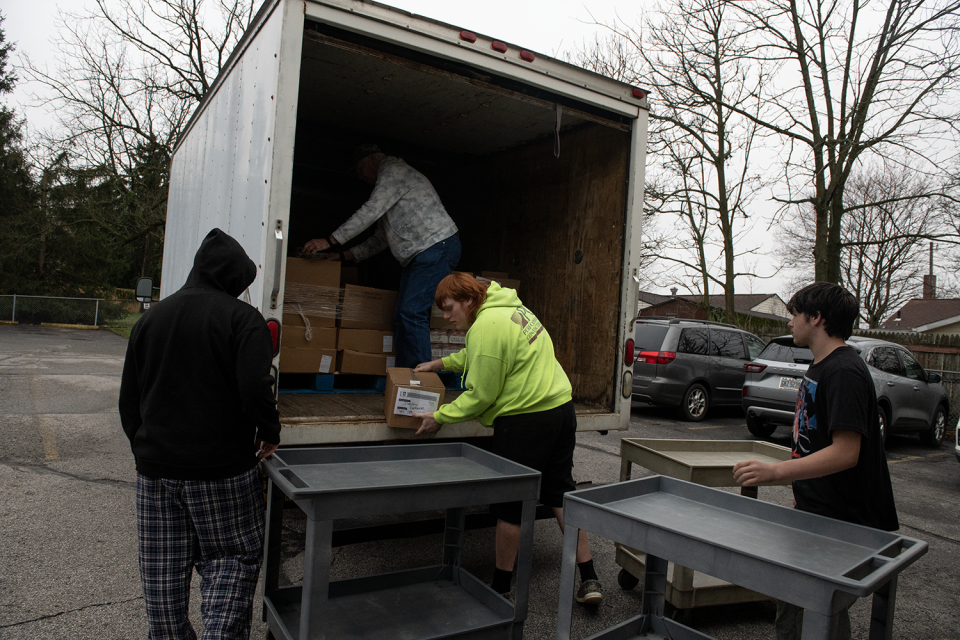 Ravenna High School students Kenyan Mack, 14, Anthony Columbus, 16, and Charles Ford, 15 volunteer at Center of Hope on Friday.