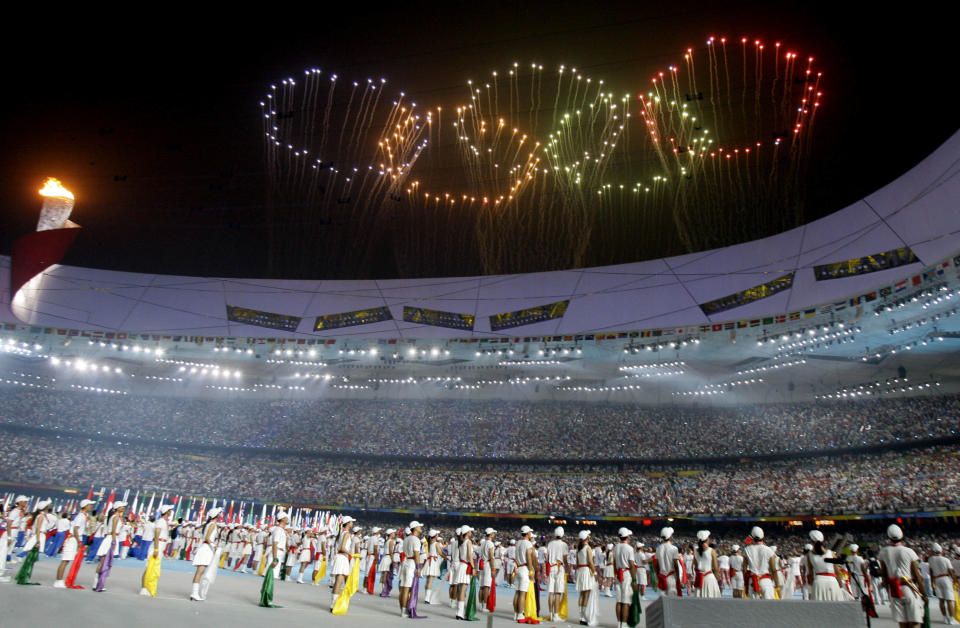FILE - Fireworks in the shape of the Olympic rings are shown over National Stadium during the closing ceremony of the Beijing 2008 Olympics in Beijing, Sunday, Aug. 24, 2008. Richer, more heavily armed and openly confrontational, China has undergone history-making change since the last time it was an Olympic host in 2008. (AP Photo/Darron Cummings, File)