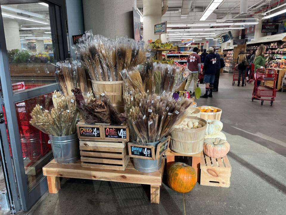 A seasonal display of gourds and flowers at Trader Joe's.