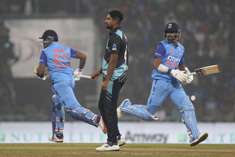New Zealand's Ish Sodhi, center, watches as India's Suryakumar Yadav, left, and Washington Sundar run between the wickets to score during the second T20 international cricket match between India and New Zealand in Lucknow, India, Sunday, Jan. 29, 2023. (AP Photo/Surjeet Yadav)
