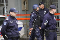 Policemen walk in front of the Ribnikar school in Belgrade, Serbia, Wednesday, May 3, 2023. Police say a 13-year-old who opened fire at his school drew sketches of classrooms and made a list of people he intended to target. He killed eight fellow students and a school guard before being arrested Wednesday. (AP Photo/Darko Vojinovic)