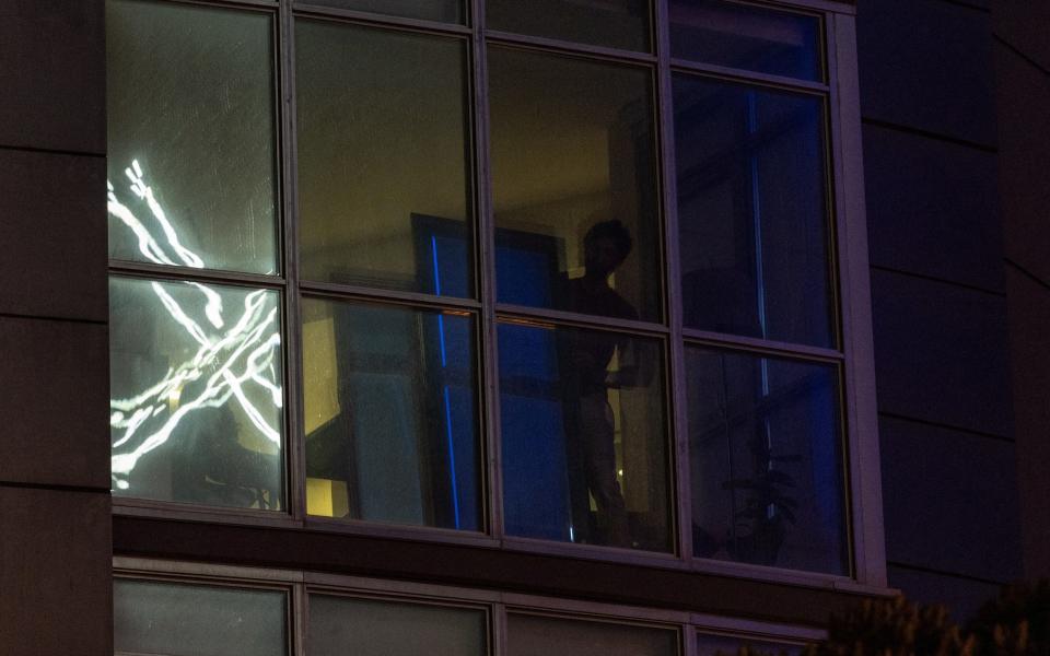 The X logo is reflect on an apartment window across the street from the headquarters