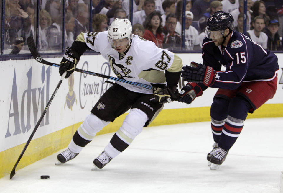 Pittsburgh Penguins' Sidney Crosby, left, tries to carry the puck past Columbus Blue Jackets' Nick Shultz during the first period of Game 6 of a first-round NHL playoff hockey series Monday, April 28, 2014, in Columbus, Ohio. (AP Photo/Jay LaPrete)