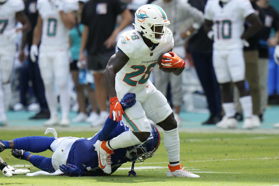 New York Giants safety Isaiah Simmons (19) grabs Miami Dolphins running back De'Von Achane (28) before Achane fumbled the ball during the first half of an NFL football game, Sunday, Oct. 8, 2023, in Miami Gardens, Fla. (AP Photo/Wilfredo Lee)