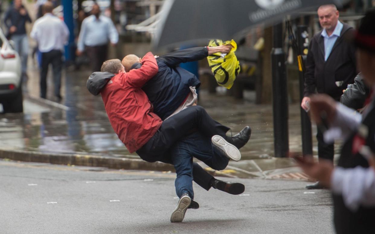 A member of the public takes down a suspected street thief after he allegedly snatched £170 from a woman as she used a Tesco Cash machine in Manchester - Allan Bentley/Cavendish Press