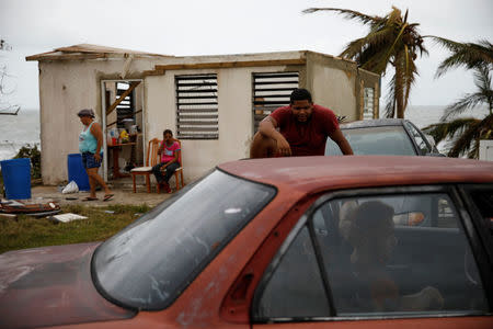 People rest outside their damaged house after the area was hit by Hurricane Maria in Yabucoa, Puerto Rico September 22, 2017. REUTERS/Carlos Garcia Rawlins