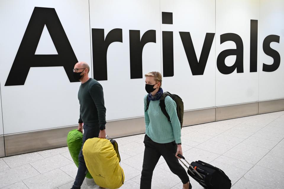 Passengers wear face masks as they arrive with their lugage at Terminal 4 of London Heathrow Airport in London. Photo: Daniel Leal-Olivas/AFP via Getty Images