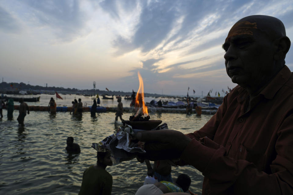 A Hindu devotee performs rituals at Sangam, the confluence of rivers the Ganges and the Yamuna during Maghi Purnima or the full-moon day at the annual traditional fair in Prayagraj, in the northern state of Uttar Pradesh, India, Saturday, Feb. 24, 2024. Hundreds of thousands of Hindu pilgrims take dips here hoping to wash away sins during a month-long festival called Magh Mela. (AP Photo/Rajesh Kumar Singh)