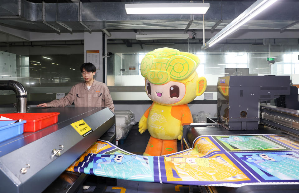 A mascot from the 19th Asian Games Hangzhou 2022 visits a factory that produces silk scarves themed for the event in Hangzhou, Zhejiang province, in China, on March 30, 2023.