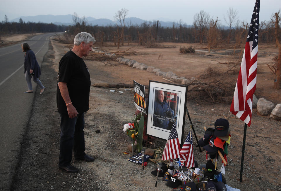 FILE - In this Aug. 11, 2018 file photo Gary Parmely, father of Jeremy Stoke of the Redding Fire Department, visits a memorial for his son, in Redding, Calif. Officials say Stoke the first firefighter to die battling a Northern California blaze was killed by a fire tornado. The California Department of Forestry and Fire Protection says in a report that Redding firefighter Jeremy Stoke died July 26, 2018, after he was enveloped in seconds by a fire tornado with a base the size of three football fields and winds up to 165 miles an hour. (AP Photo/John Locher,File)