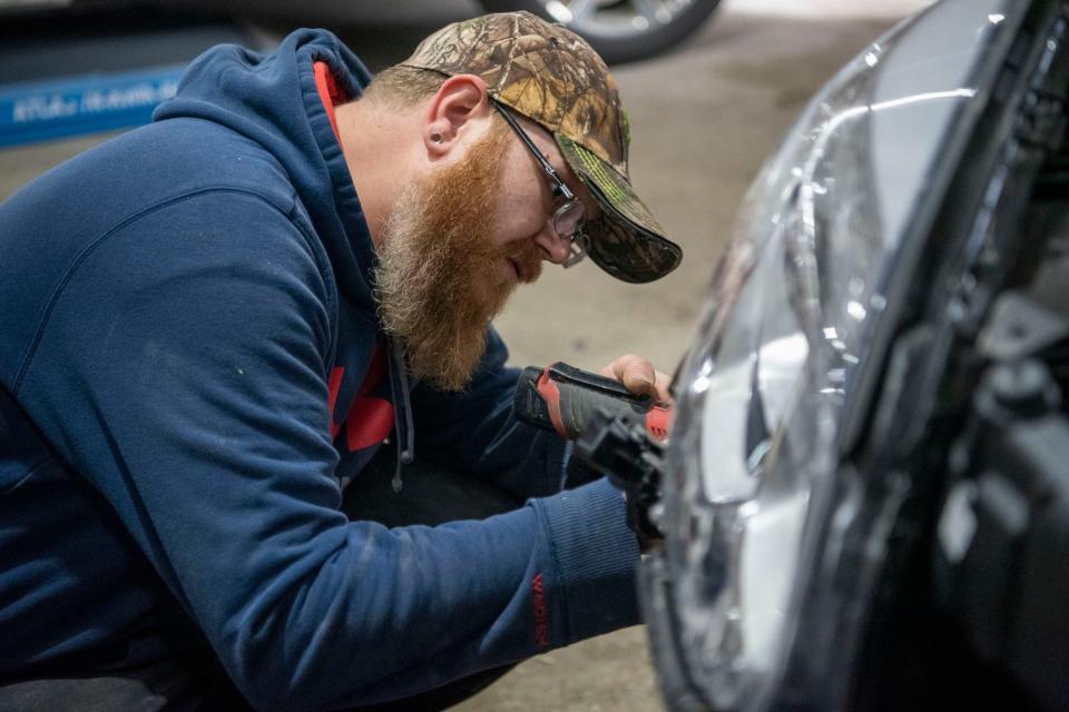 Rick Kocher applies a bumper on a vehicle on Tuesday, Dec. 14, 2021, at Lakeview Body Shop in Battle Creek, Michigan.