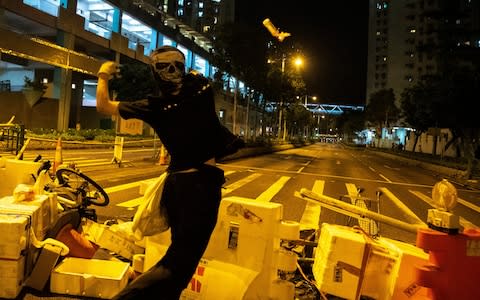 An anti-government protester throws a Molotov cocktail in Hong Kong - Credit: Athit Perawongmetha/Reuters