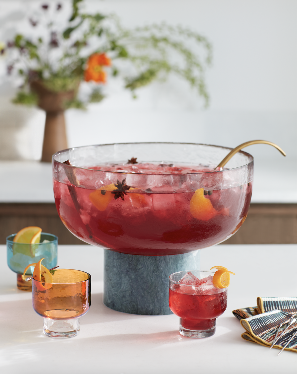 a glass of red liquid with a lemon slice on top