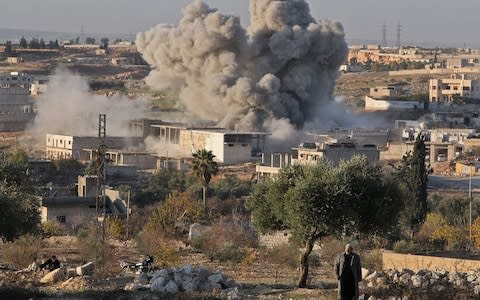 A smoke plume billows following a reported Syrian government air strike on a residential district of Maaret al-Numan in the northwestern Idlib province - Credit: AFP