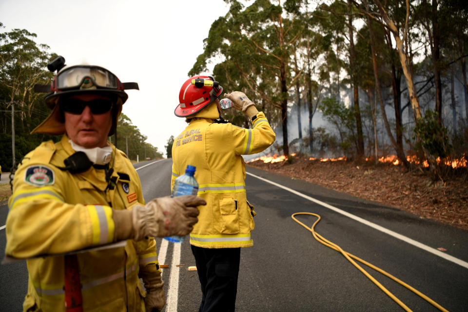 Firefighters keep a watchful eye on a fire threatening homes along the Princes Highway near in Milton, Australia January 5, 2020. REUTERS/Tracey Nearmy