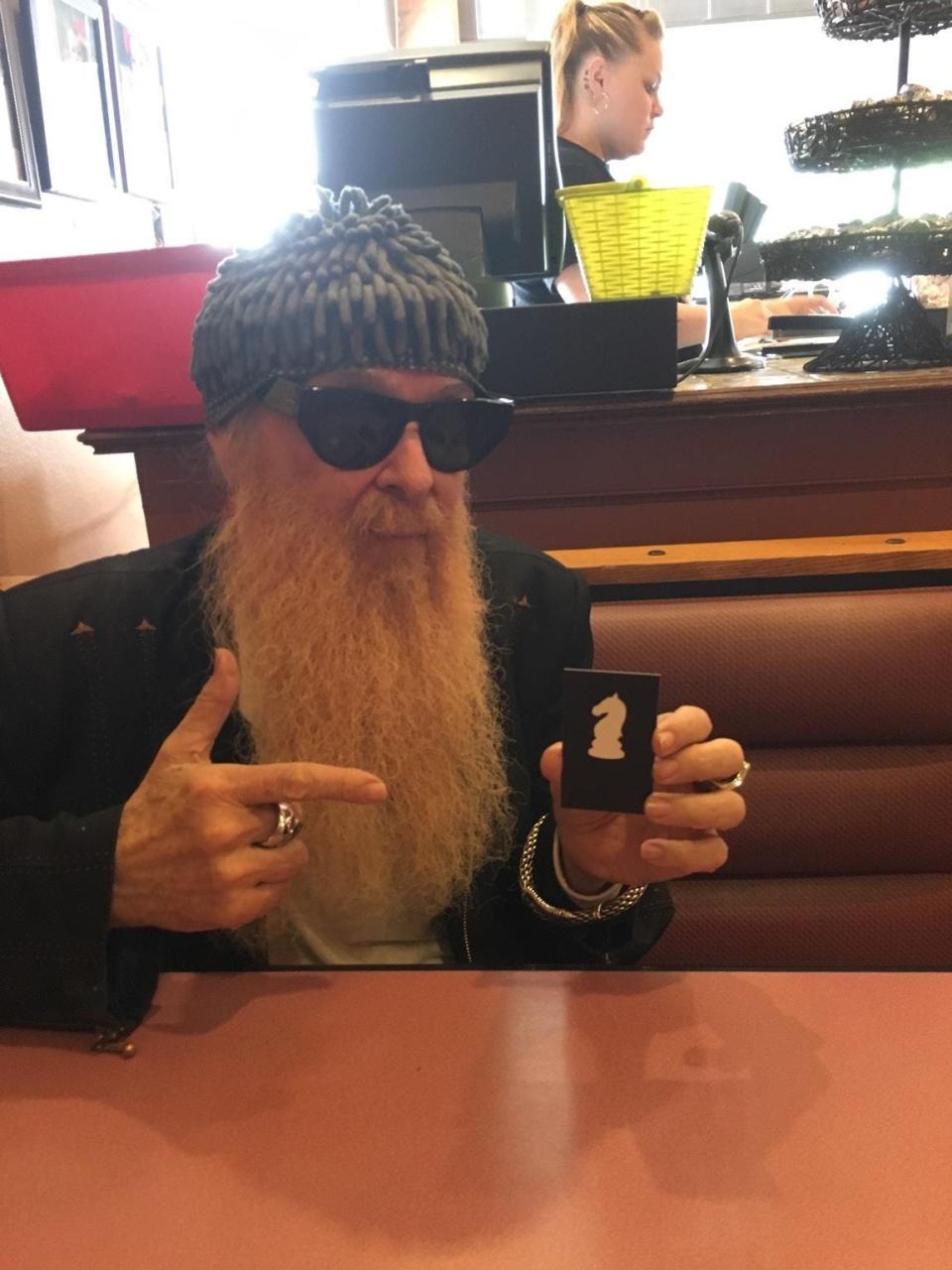 Billy Gibbons of ZZ Top holds a business card belonging to Stephen McLaughlin of McLaughlin Advertising while seated at Fuentes Cafe in downtown San Angelo. May 22, 2017.