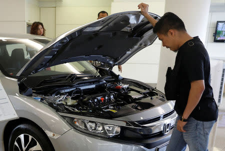 A prospective buyer looks at a car at a showroom in Malaysia's southern city of Johor Bahru April 26, 2017. REUTERS/Edgar Su