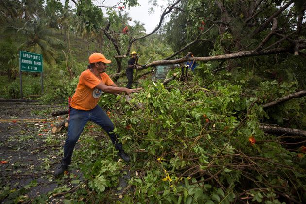 Civil defense personnel and firefighters work to remove fallen trees from the highway that connects the provinces of Maria Trinidad Sanchez and Samana, Dominican Republic, on Monday, after the passage of Hurricane Fiona. (Photo: ERIKA SANTELICES via Getty Images)