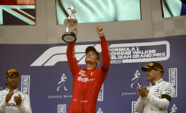 Ferrari driver Charles Leclerc of Monaco, center, lifts the trophy after finishing first in the Belgian Formula One Grand Prix in Spa-Francorchamps, Belgium, Sunday, Sept. 1, 2019. Mercedes driver Lewis Hamilton of Britain, left, placed second and Mercedes driver Valtteri Bottas of Finland, right, placed third. (AP Photo/Francisco Seco)