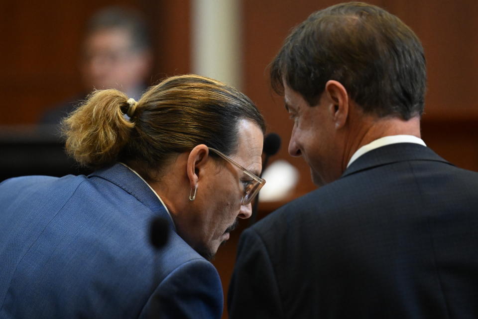 Actor Johnny Depp talks to his attorney Ben Chew in the courtroom at the Fairfax County Circuit Courthouse in Fairfax, Va., Tuesday, May 24, 2022. Depp sued his ex-wife Amber Heard for libel in Fairfax County Circuit Court after she wrote an op-ed piece in The Washington Post in 2018 referring to herself as a "public figure representing domestic abuse." (Jim Watson/Pool photo via AP)