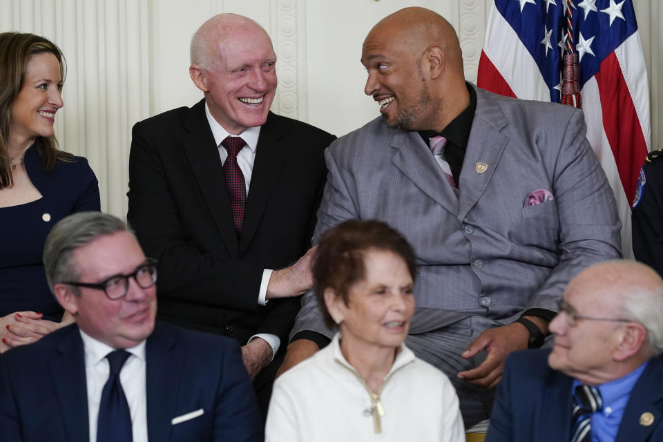 U.S. Capitol Police Sgt. Harry Dunn, top right, and Jocelyn Benson, Michigan secretary of state, left, look to Rusty Bowers, former Arizona state House Speaker, top center, as President Joe Biden recognizes Bowers during a ceremony to mark the second anniversary of the Jan. 6 assault on the Capitol and to award the nation's second-highest civilian honor in the East Room of the White House in Washington, Friday, Jan. 6, 2023. (AP Photo/Patrick Semansky)