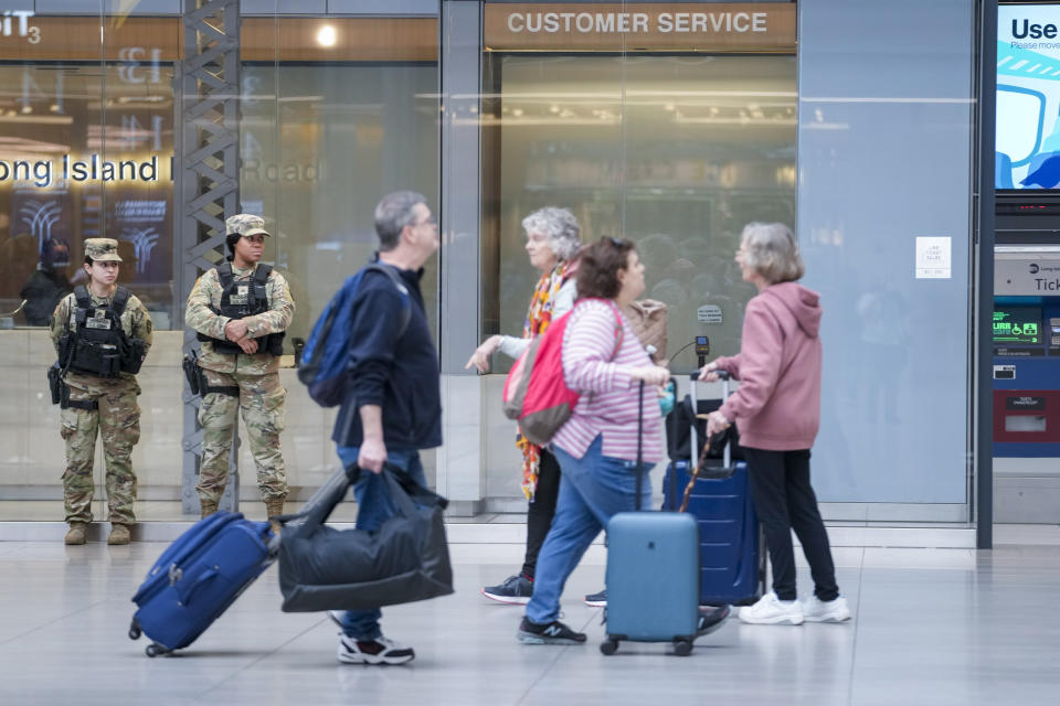 Commuters walk past a couple of New York National Guard soldiers stand guard a the Moynihan Train Hall at Penn Station, Thursday, March 7, 2024, in New York. New York Gov. Kathy Hochul announced plans Wednesday to send the National Guard to the New York City subway system to help police conduct random searches of riders' bags for weapons following a series of high-profile crimes on city trains. (AP Photo/Mary Altaffer)