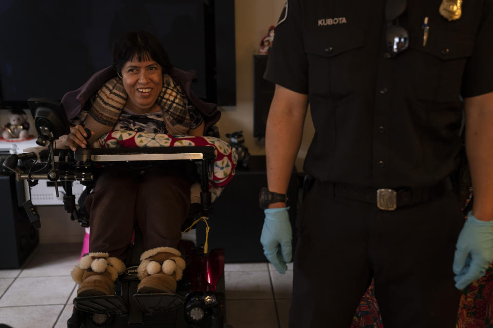 Barbara Franco, who has muscular dystrophy, smiles while talking to Torrance firefighters after receiving the second dose of the Pfizer COVID-19 vaccine at her apartment, Wednesday, May 12, 2021, in Torrance, Calif. Teamed up with the Torrance Fire Department, Torrance Memorial Medical Center started inoculating people at home in March, identifying people through a city hotline, county health department, senior centers and doctor's offices, said Mei Tsai, the pharmacist who coordinates the program. (AP Photo/Jae C. Hong)