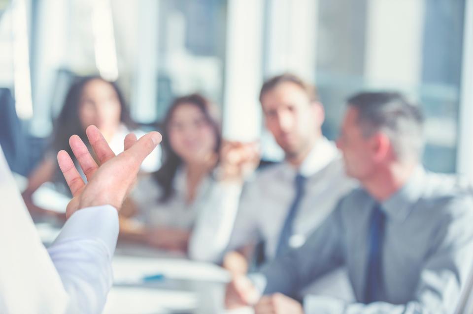 A blurred photo of a workplace meeting