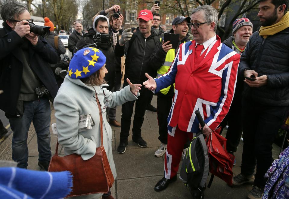 An anti-Brexit, left, and pro-Brexit supporter debate outside the House of Parliament in London, Tuesday, March 12, 2019. Prime Minister Theresa May's mission to secure Britain's orderly exit from the European Union appeared headed for defeat Tuesday, as lawmakers ignored her entreaties to support her divorce deal and end the political chaos and economic uncertainty that Brexit has unleashed.(AP Photo/Tim Ireland)