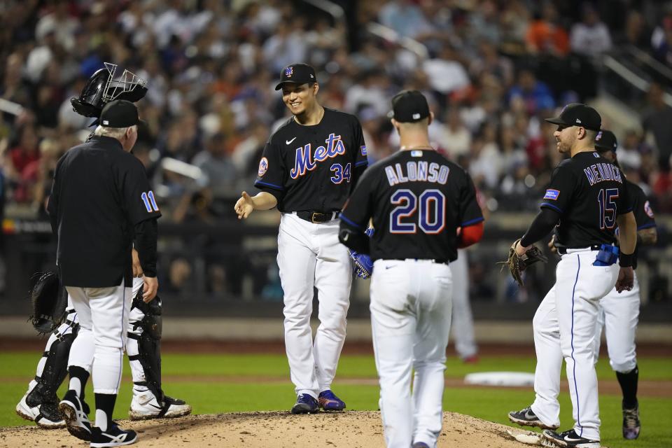 New York Mets starting pitcher Kodai Senga (34), of Japan, smiles at manager Buck Showalter (11) before leaving during the seventh inning of a baseball game against the Los Angeles Angels, Friday, Aug. 25, 2023, in New York. (AP Photo/Frank Franklin II)