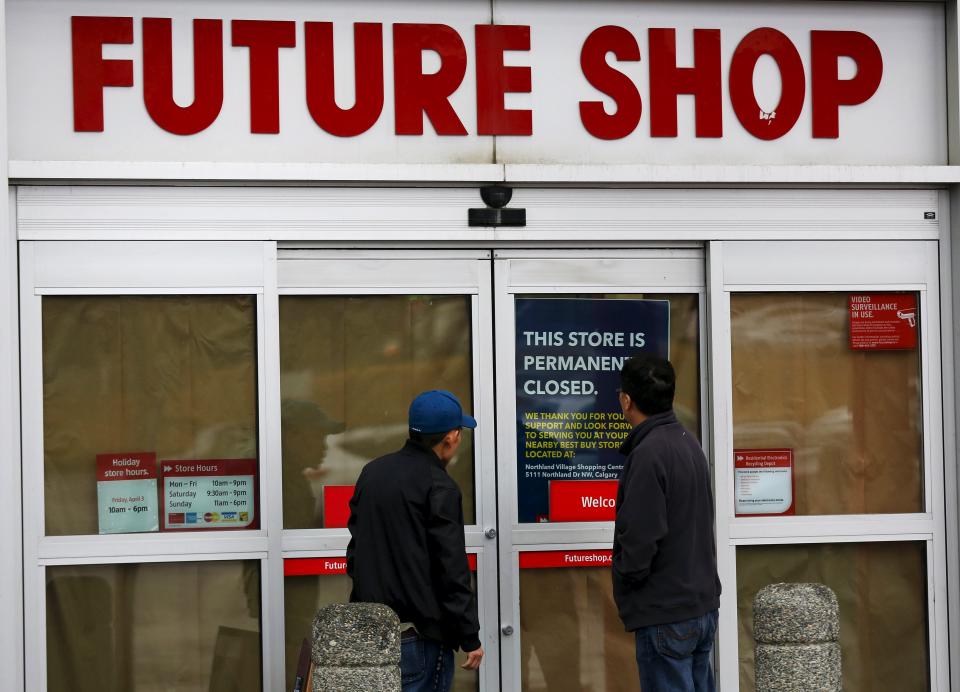 Two men read a notice on the door of a closed Future Shop store in Calgary, Alberta March 28, 2015. Best Buy Co Inc said it will close 66 of its Future Shop brand stores in Canada and convert 65 of them to Best Buy brand stores. REUTERS/Todd Korol