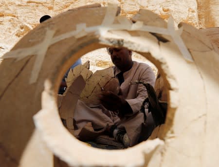 An Egyptian archaeologist works on objects discovered through an archaeological mission in the Monkey Valley near the Valley of the Kings in Luxor