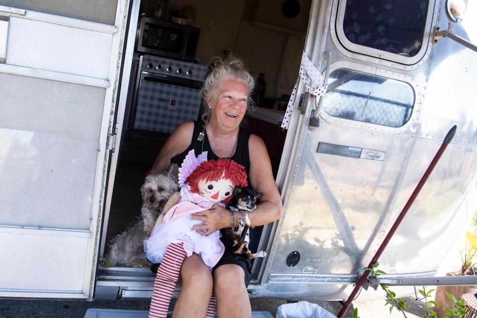 Sharon Pastore, with her pups Brody and Paisley sit outside a 1974 Airstream trailer parked at the Walmart Supercenter in Fort Myers, Fla. on Friday, October 7, 2022. The Pastore's, who operated a catamaran charter tour business, rode out Hurricane Ian behind a Publix before relocating to a Wal-Mart parking lot nearby. 