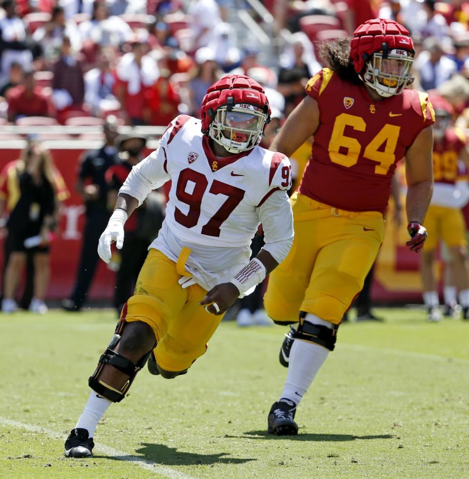 Offensive lineman Earl Barquet Jr. and defensive lineman AJ Mageo react to the ball during the spring game