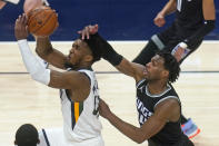 Utah Jazz guard Donovan Mitchell, left, goes to the basket as Sacramento Kings guard Buddy Hield, right, defends in the second half during an NBA basketball game Saturday, April 10, 2021, in Salt Lake City. (AP Photo/Rick Bowmer)