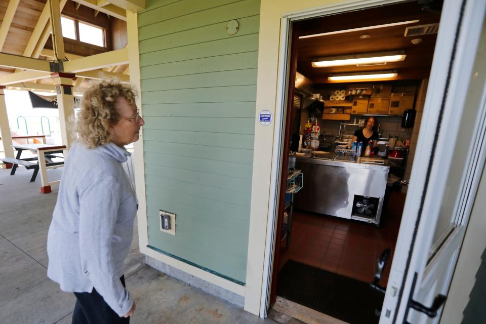 A woman asks Monica Ferracioli when Sorbae Frozen Treats at Fort Taber Park in New Bedford will open.