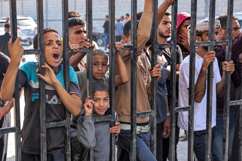 Relatives await the arrival of Palestinian workers who were stranded in Israel since the October 7 attacks as they cross back into the Gaza Strip at the Kerem Shalom commercial border crossing with Israel in the south of the Palestinian enclave on Nov. 3, 2023.