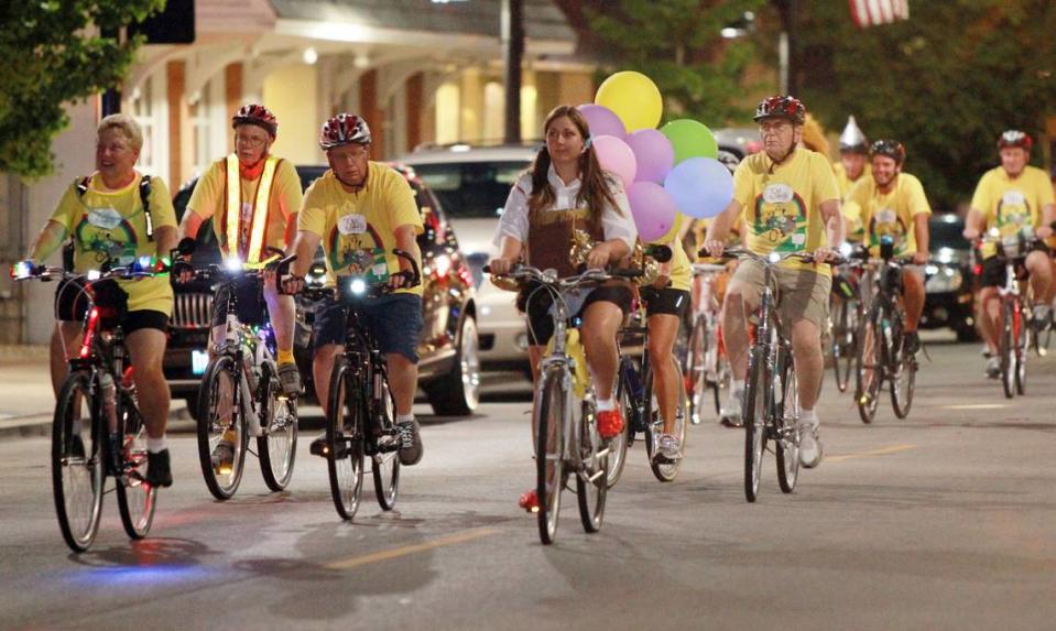 Bicyclists, including Tara Renneke in a Dorothy costume, make their way down East Main Street.