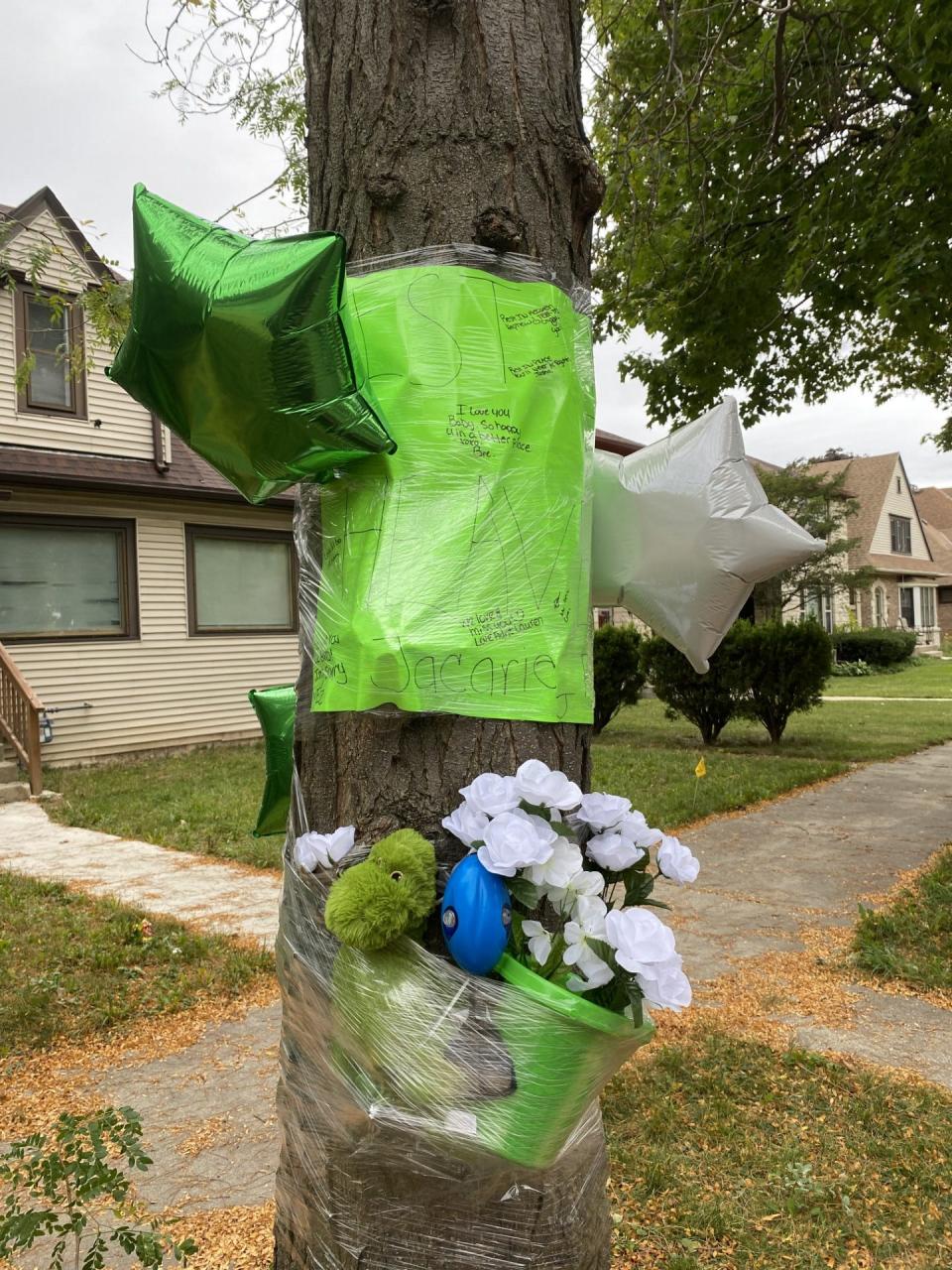 Flowers and balloons were laid out in a memorial for Jacarie Robinson outside the home where his body was found on Milwaukee's northwest side.