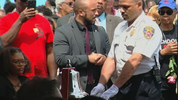 PHOTO: A firefighter rings a silver bell 13 times at 2:28 p.m. in Buffalo, New York, on May 14, 2023, to mark the time 1-year ago that 10 Black people were killed and three other people were wounded in the Tops grocery store shooting. (WKBW)
