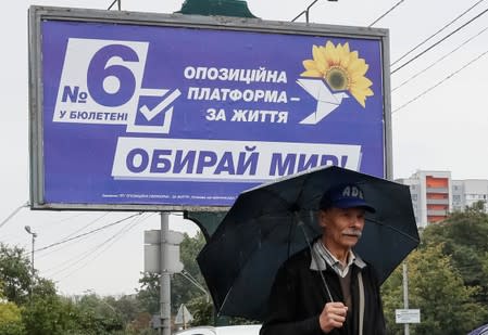 A man walks past an election campaign poster of Ukrainian Opposition Platform - For Life political party in Kiev