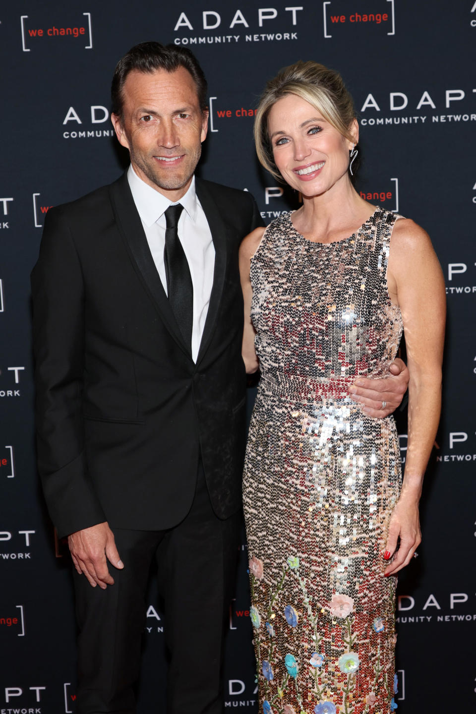 andrew shue and amy robach pose on a red carpet