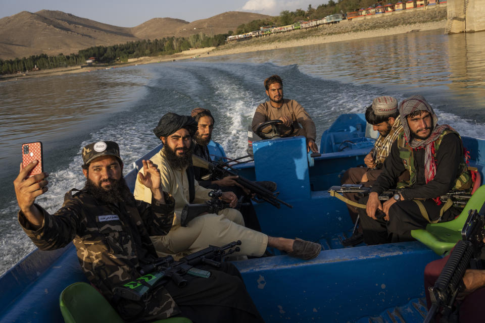 Taliban fighters enjoy a boat ride in the Qargha dam, outskirt of Kabul, Afghanistan, Friday, Sept. 24, 2021. (AP Photo/Bernat Armangue)