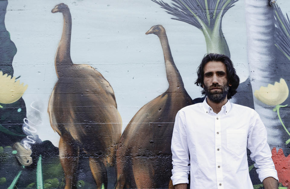 In this Nov. 19, 2019, photo, Behrouz Boochani, the Kurdish film-maker, writer and refugee who has documented life inside the Australian offshore immigration camp on Manus Island, poses for a portrait in Christchurch, New Zealand. (AP Photo/Mark Baker)