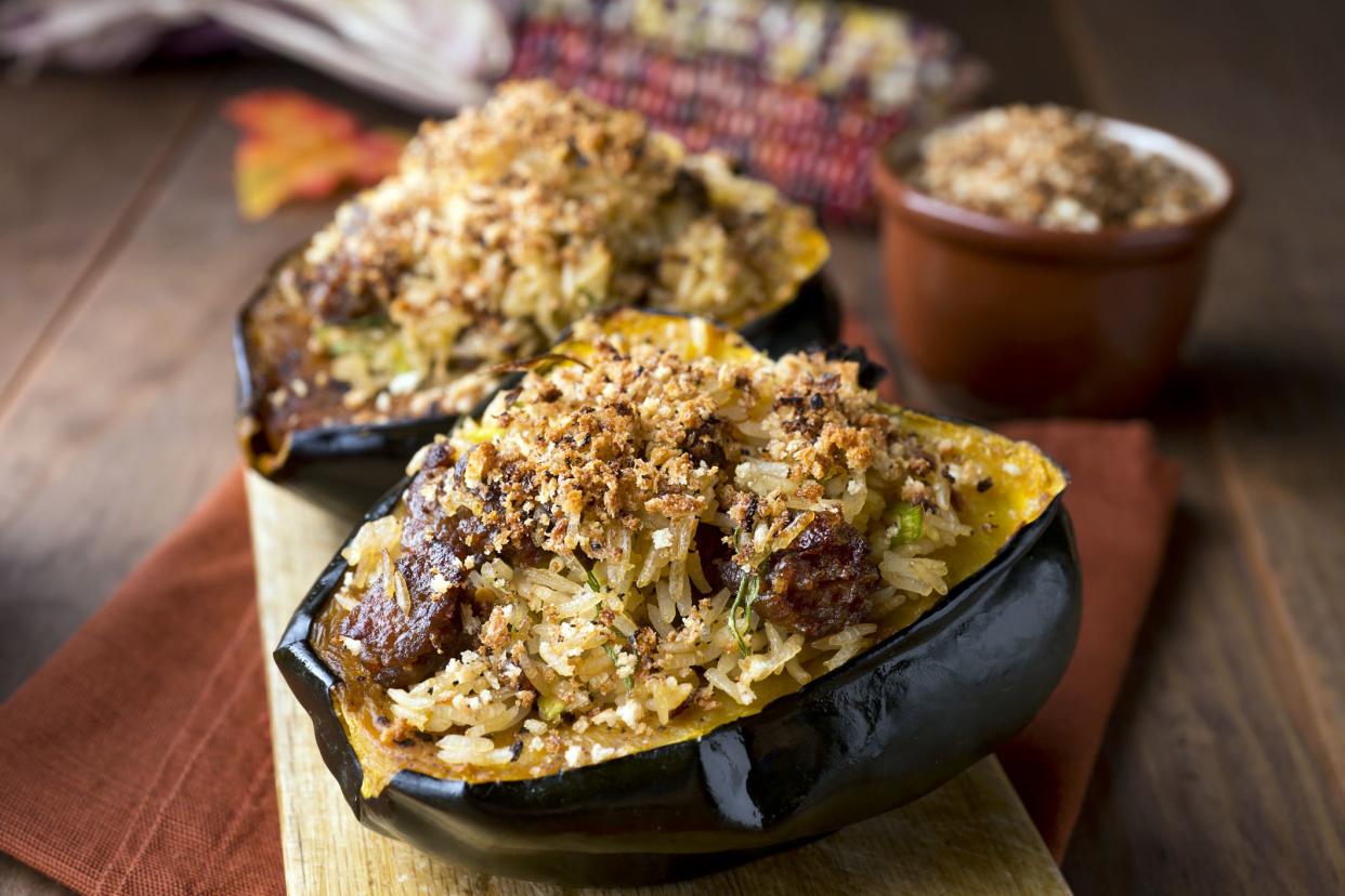 stuffed acorn squash with rice on wooden cutting board