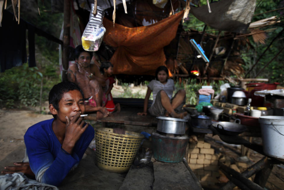 In this Feb. 12, 2014 photo, a Myanmarese illegal logger smokes a cigarette at one of the illegal logging camps on army-controlled Jar Lann Island in Mergui Archipelago, Myanmar. The perilous state of Lampi, Myanmar’s only marine park, is not unique. Though the country’s 43 protected areas are among Asia’s greatest bastions of biodiversity, encompassing snow-capped Himalayan peaks, dense jungles and mangrove swamps, they are to a large degree protected in name alone. Park land has been logged, poached, dammed and converted to plantations as Myanmar revs up its economic engines and opens up to foreign investment after decades of isolation. (AP Photo/Altaf Qadri)