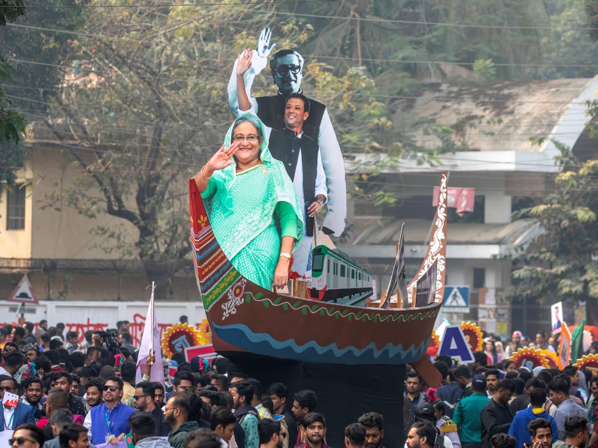 Portraits of prime minister Sheikh Hasina, her son Sajeeb Ahmed Wazed and her father Bangabandhu Sheikh Mujibur Rahman taken out by Bangladesh Chhatra League (EPA)